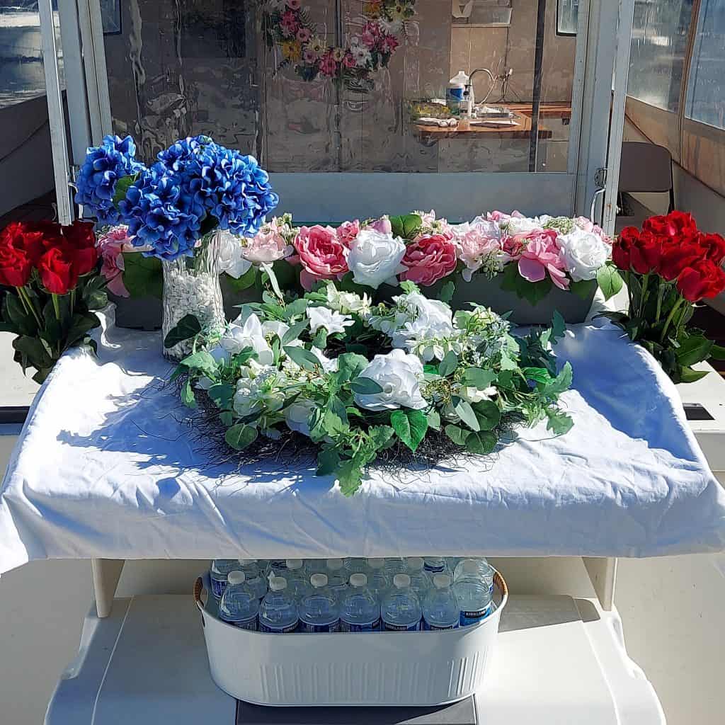 Floral wreaths and bouquets for NY Sea Burials Long Island & Queens arranged on a white table.