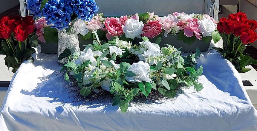 Floral wreaths and bouquets for NY Sea Burials Long Island & Queens arranged on a white table.